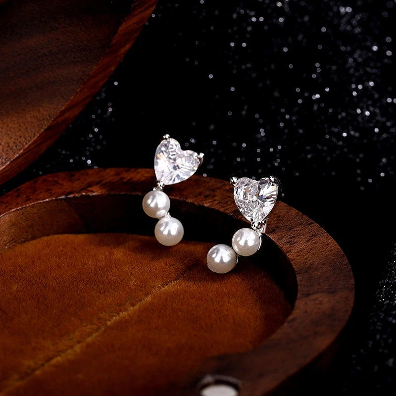 Model showcasing the dangle and style of the Sterling Silver Zircon Heart Imitation Pearl Stud Earrings