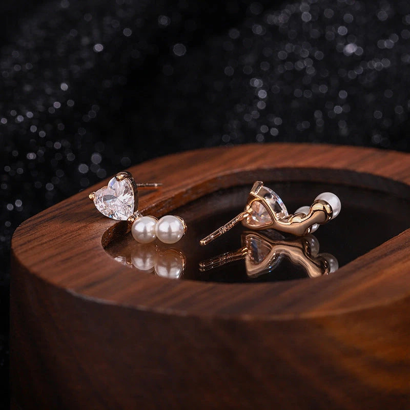 Angled view of the Sterling Silver Zircon Heart Imitation Pearl Stud Earrings