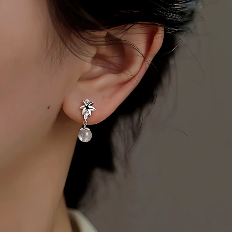 Model showcasing the dangle and style of the Sterling Silver Zircon Maple Leaf Earrings