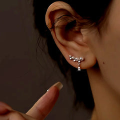 Model showcasing the dangle and style of the Sterling Silver Zircon Pearl Crawler Earrings