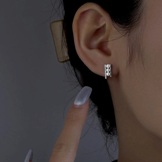 Model showcasing the dangle and style of the Sterling Silver Zircon Pearl Stud Earrings
