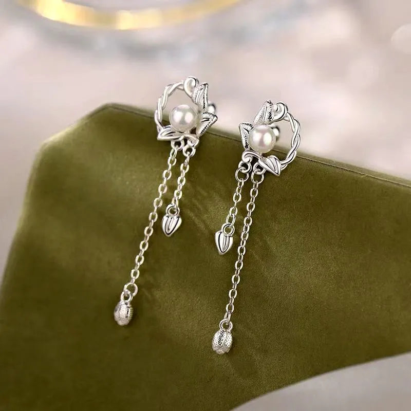 Model showcasing the dangle and style of the Sterling Silver Zircon Pearl Tassel Earrings