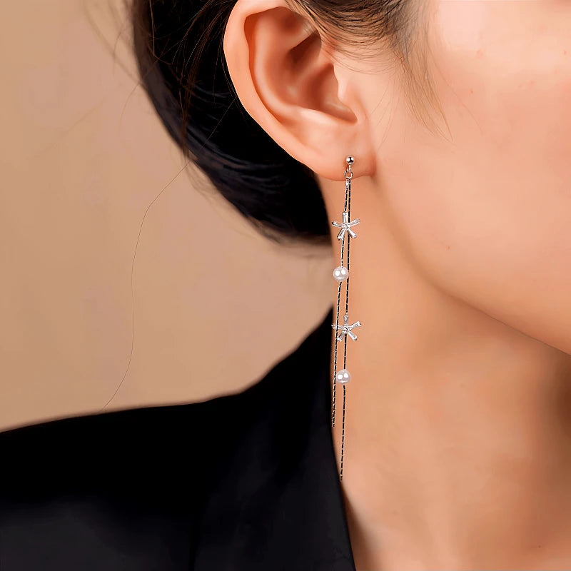 Model showcasing the dangle and style of the Sterling Silver Zircon Star Pearl Earrings