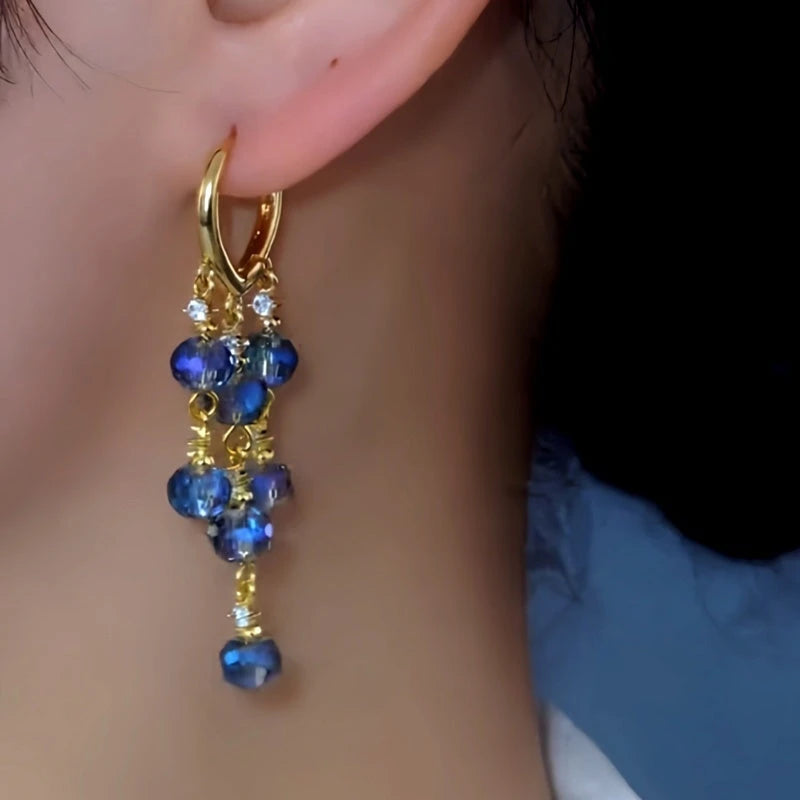 Model showcasing the dangle and style of the 14K Gold-Plated Elegant Blue Crystal Water Drop Tassel Earrings