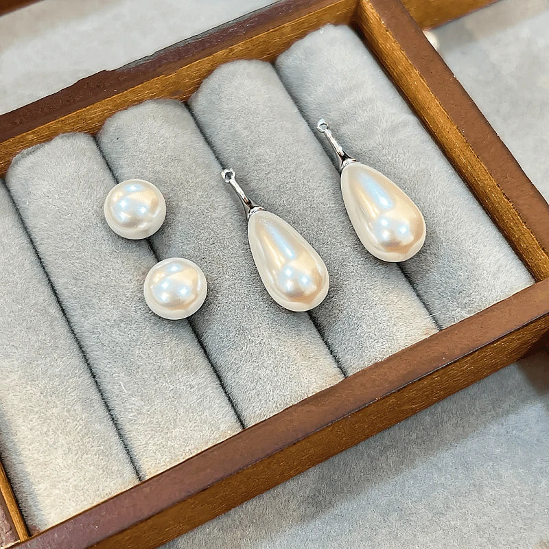 White pearl earring set with round studs and teardrop drops in wooden velvet jewelry box