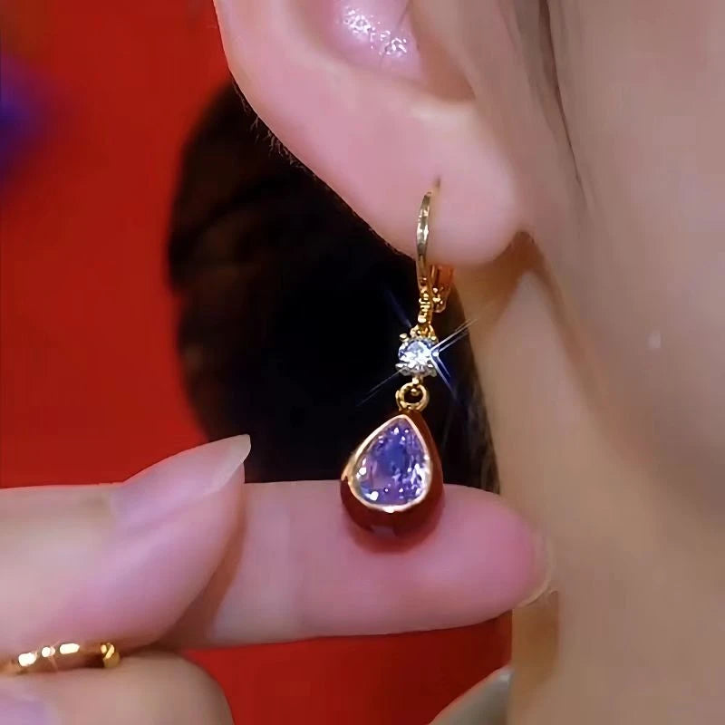 Model showcasing the dangle and style of the 14K Gold-Plated Luxury Zircon Purple Crystal Water Drop Earrings
