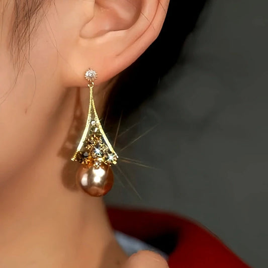 Model showcasing the dangle and style of the 14K Gold-Plated Brown Diamond Pearl Earrings