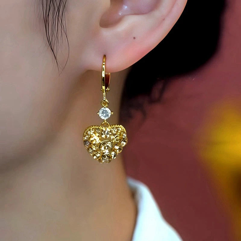 Model showcasing the dangle and style of the 14K Gold-Plated Elegant Zircon Heart Earrings