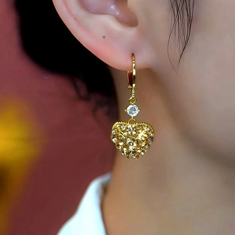 Close-up detail of the sparkling zircons and plating on the gold heart earrings
