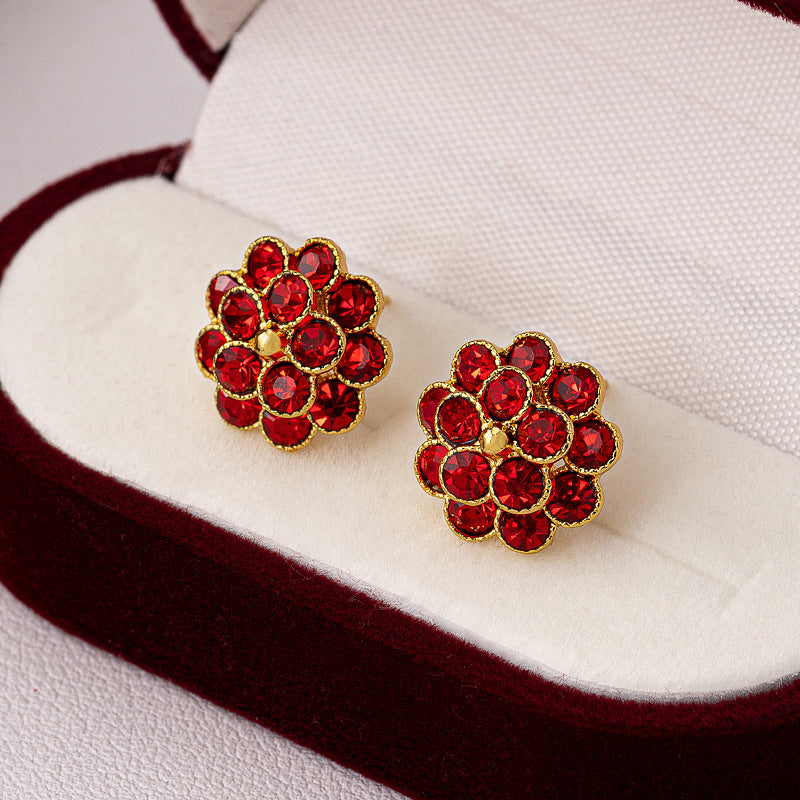Gold-tone red rhinestone flower stud earrings in velvet jewelry box