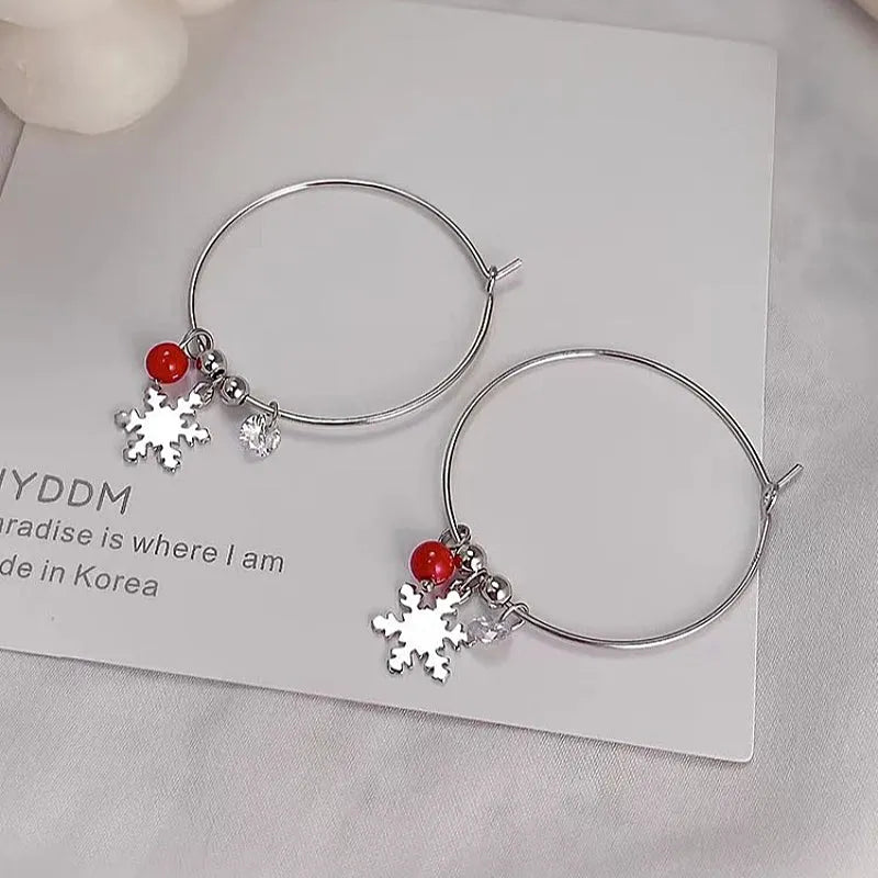 Model showcasing the dangle and style of the Sterling Silver Christmas Snowflake Hoop Earrings