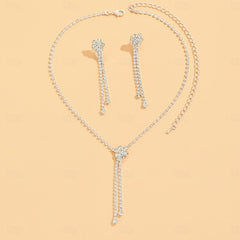 Silver pave rhinestone Y-tassel necklace and matching drop earring set on peach background