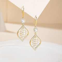Pair of gold CZ leaf-shaped drop dangle earrings on neutral paper display