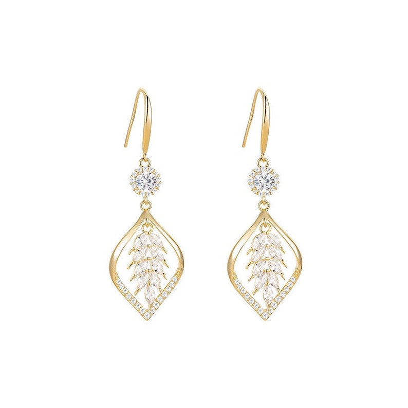 Gold cubic zirconia leaf dangle hook earrings on white background
